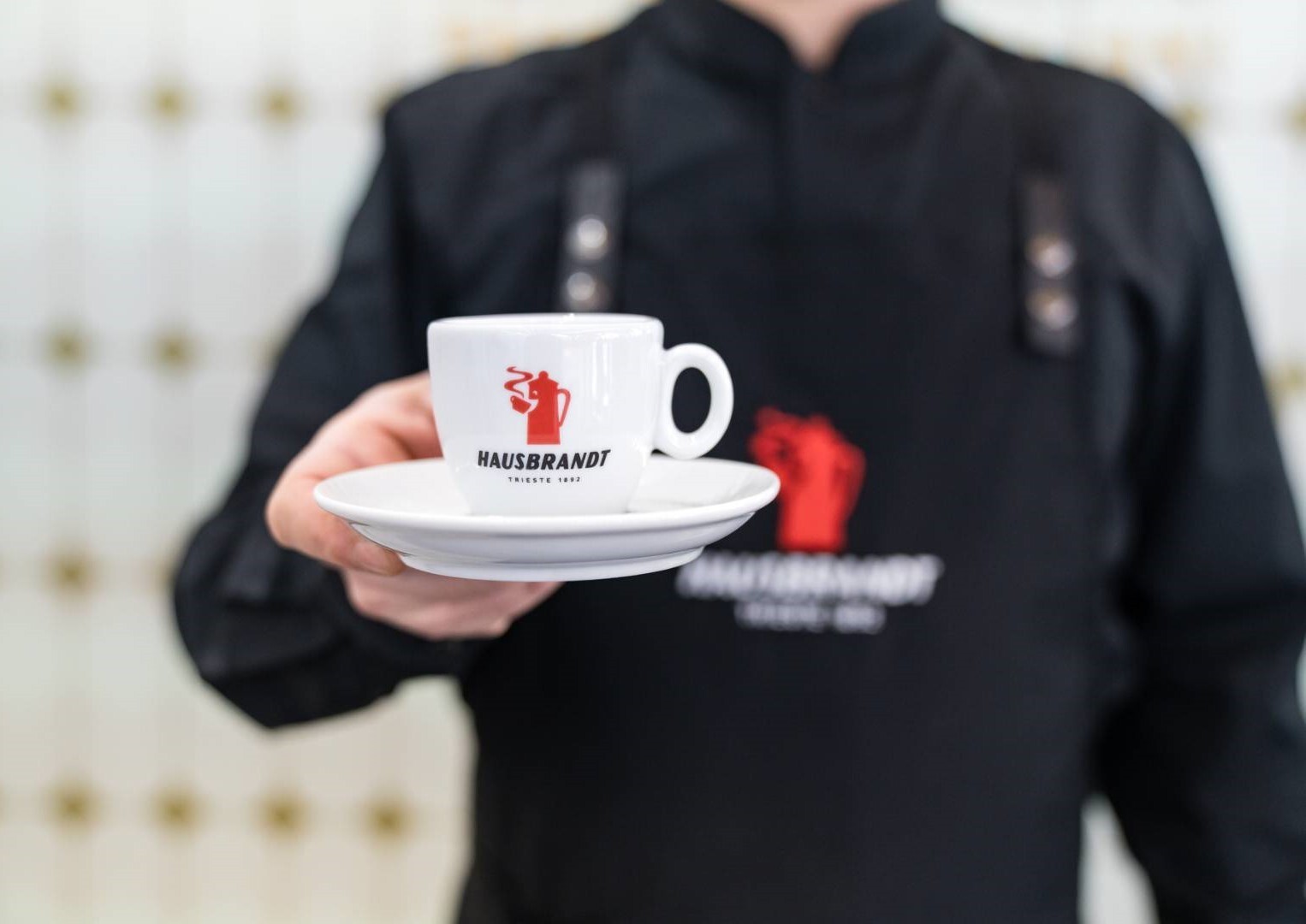 Barista Hausbrandt entregando un café espresso